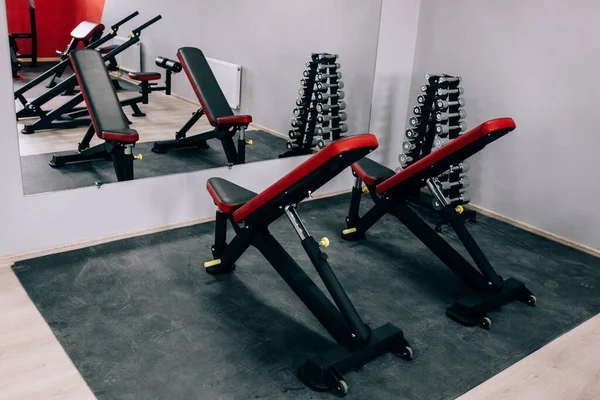 Modern light gym. Sports equipment in gym. Barbells of different weight on rack