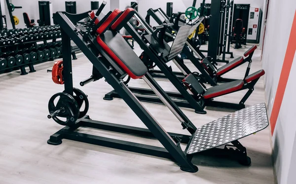 Φως σύγχρονο γυμναστήριο. Αθλητικά μηχανήματα στο γυμναστήριο. Barbells διαφορετικό βάρος σε ράφι — Φωτογραφία Αρχείου