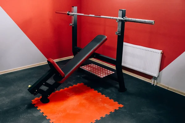 Modern light gym. Sports equipment in gym. Barbells of different weight on rack.