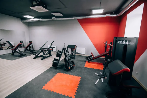 Modern light gym. Sports equipment in gym. Barbells of different