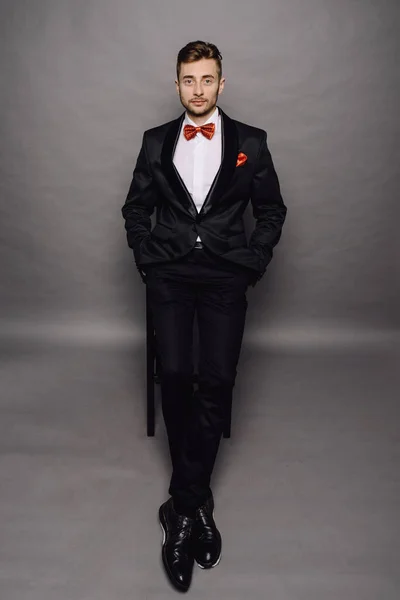 Элегантный деловой человек в костюме на сером фоне студии — стоковое фото