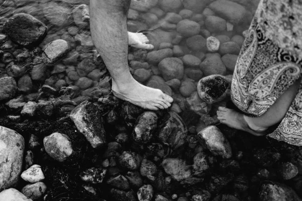 Pareja con los pies desnudos de pie en el río con agua clara —  Fotos de Stock