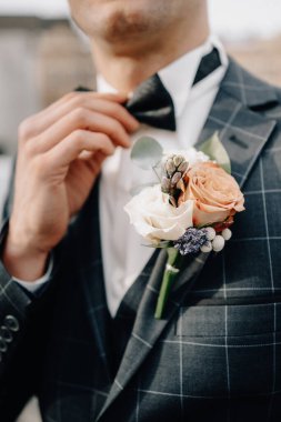Smokinli ve papyonlu damat papyonunu düzeltti. Düğün için. Ayrıntılar