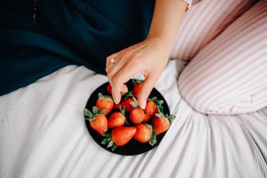 Genç kadın yatakta sağlıklı kahvaltı