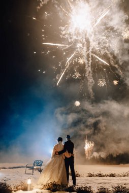 Düğün havai fişekleri. Gelin ve damat havai fişek gösterisinde sarılıyor ve selam veriyor. Düğün kısmı.