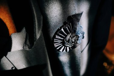 Çiçek şeklinde örülmüş broş ve cep mendili ve bir adamın mavi takımının göğüs cebinde nakış. Düğün aksesuarları