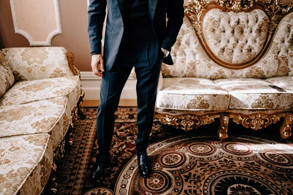 Saygıdeğer genç bir adam klasik iç mimarisi olan bir odada duruyor. Lüks. Erkek güzelliği, moda.