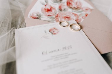 Şakayıklı narin bir buket. Gelinin düğün aksesuarları. Kurdeleli şık bir düğün buketi, düğün davetiyeleri, nişan yüzükleri ve sandalyede oturan gelin için ayakkabılar. seçici odak