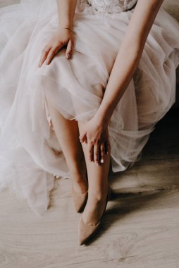 Gelin düğün töreninden önce ayakkabı giyer. Gelinin suçlamaları. Gelinin yüksek topuklu düğün ayakkabıları giydiği yakın plan detayları. Gelinin ayakkabıları. Güzel bacaklar