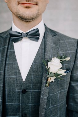 Gelinin eli damadın ceketine yaka çiçeği takar. Gelin, damat elbisesine düğme deliği açıyor.