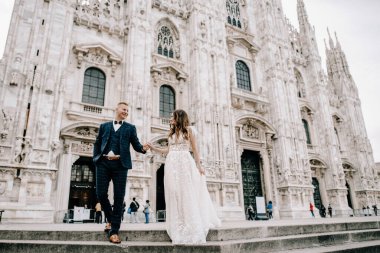 Gelin ve damat kilisenin önünde poz veriyor.