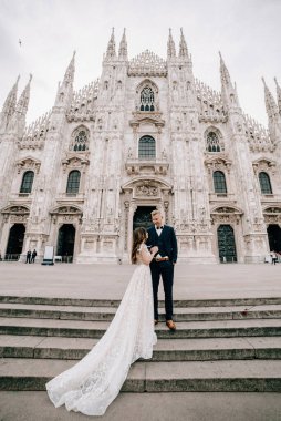 Gelin ve damat kilisenin önünde poz veriyor.