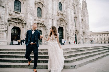 Gelin ve damat kilisenin önünde poz veriyor.