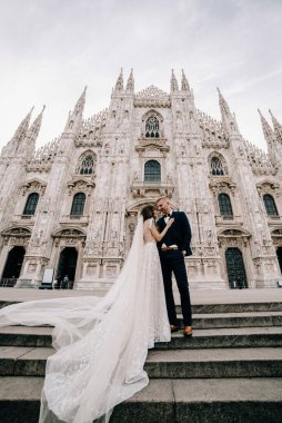 Gelin ve damat kilisenin önünde poz veriyor.