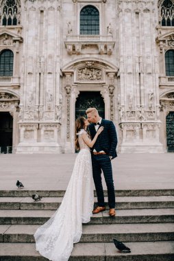 Gelin ve damat kilisenin önünde poz veriyor.