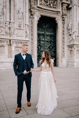 Gelin ve damat kilisenin önünde poz veriyor.