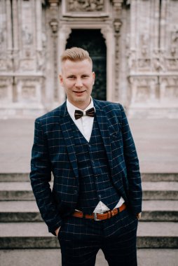 Şık damat şehirde poz veriyor.