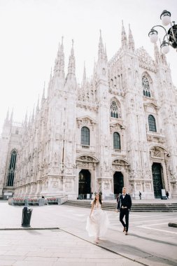 Gelin ve damat kilisenin önünde poz veriyor.