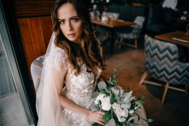 Gelinlikli genç gelinin portresi. Elinde buket var.