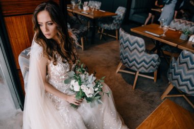 Gelinlikli genç gelinin portresi. Elinde buket var.