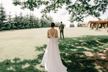 İlk buluşma. Gelin gidiyor, damada geri dönüyor, sürpriz. Damat gelinini bekliyor. Takım elbiseli genç bir adam elinde bir buket çiçekle terasta duruyor.