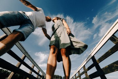 Yaz günbatımı gölde rıhtımda oturan sevgi dolu çift