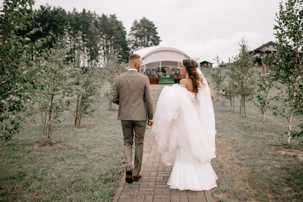 Recém Casados Estão Andando Parque Noiva Está Segurando Buquê Casamento — Fotografia de Stock