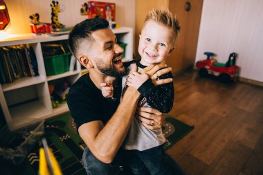 Olgun baba ve küçük oğlu koltukta oturuyor, dinleniyor..