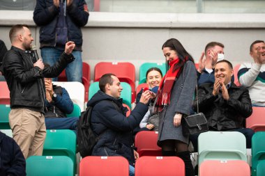 MINSK, BELARUS - 24 Mayıs 2020 Belarus Kupası Finali. Dinamo Stadyumu 'nda (Minsk) FC BATE Borisov ve FC Dinamo Brest arasında oynanan futbol maçı. Bir evlilik teklifi. Adam bir kadına evlenme teklif eder ve nişan yüzüğü verir.. 