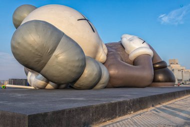 Doha-Katar, 16 Kasım 2019: Doha Cor 'da Kaws Tatil Sanatı kurulumu Gökyüzünde bulutlarla Gün Işığı