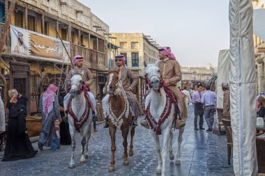 Doha-Katar, 24 Ocak 2013: Doha Katar 'da Souk Waqif ana cadde gündüz aydınlığı manzaralı geleneksel muhafızlar ve yürüyen insanlarla