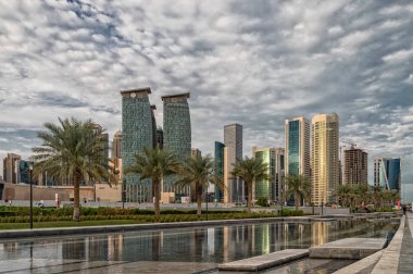 Doha, Qatar-November 18,2019: Doha, Qatar  Skyline daylight view from Sheraton park with reflection in the water and clouds in sky in background
