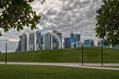 Doha, Qatar-November 18,2019: Doha, Qatar  Skyline daylight view from Sheraton park  with clouds in sky in background clipart