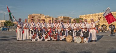 Doha, Katar-4 Ocak 2019: Katar ve Ürdün bayraklarını Souk Waqif, Doha Katar 'da taşıyan Ürdün halk dansları grubu 
