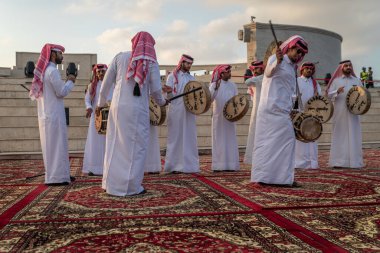 Doha, Katar-11 Aralık 2019: Katara kültür köyünde Katar geleneksel folklor dansı (Ardah dansı), Katar-Katar arka planda amfitiyatro ile