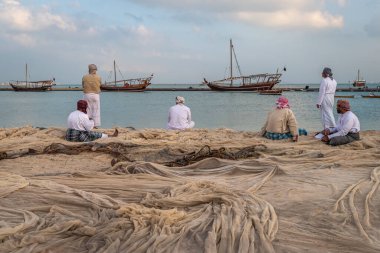 Doha, Katar-11 Aralık 2019: Geleneksel Arap balıkçılar, Katara sahilinde oturuyor ve duruyorlar.. 