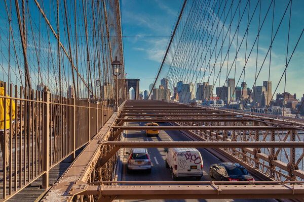 New York, USA-December 20, 2019: Brooklyn Bridge daylight view with cars moving on the bridge ,skyline and clouds in sky in background