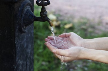 Su sıçrama, arkadan aydınlatmalı akşam güneşi tarafından elle.