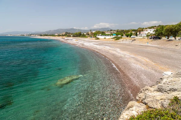 Rodos adası Kiotari 'deki çakıl taşı plajı, Yunanistan' da farklı renkte taşlar ve turkuaz berrak su
