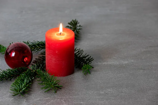 Рождественский мотив с красной горящей свечой, елки Нордмана — стоковое фото