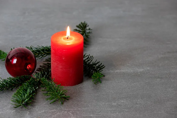 Motivo navideño con vela ardiente roja, ramas de abeto Nordmann —  Fotos de Stock