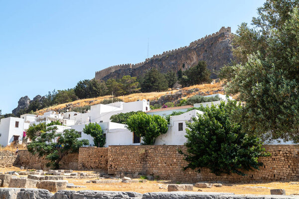 View at the acropolis of Lindos on Greek island Rhodes with white houses in the foreground on a sunny day in spring