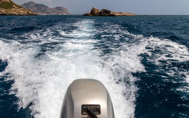 Ön planda motoru olan bir motorlu teknenin kıç dalgası. 