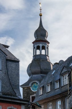 Monschau, Eifel, Almanya 'da altın kuğu ile kilise kulesine bakın.
