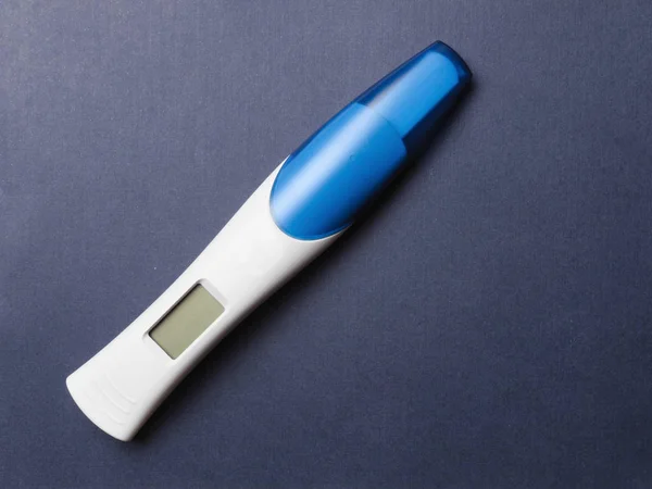 Mavi arka planda LCD ekranlı, boş elektronik hamilelik testi. Boşluğu kopyala, üst görünüm