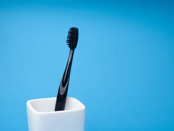 One Black Toothbrush Oral Care White Toothbrush Holder Blue Background — Stock Photo, Image