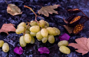 Yapraklarla süslenmiş üzümler.