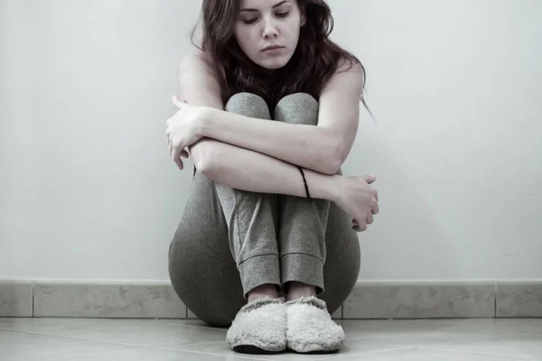 Girl sitting alone with expression of loneliness sadness and depression. Stock Photo