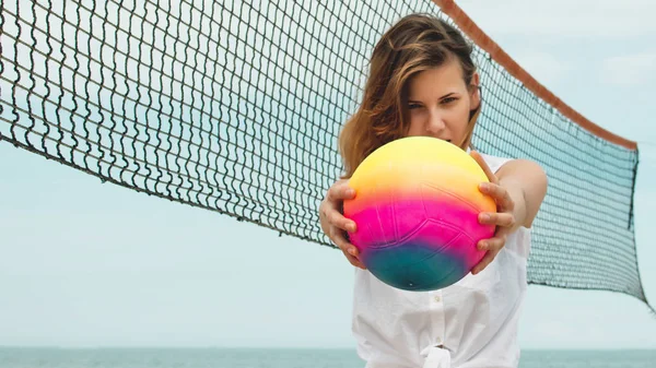 pretty girl play beach volley ball holding the ball.