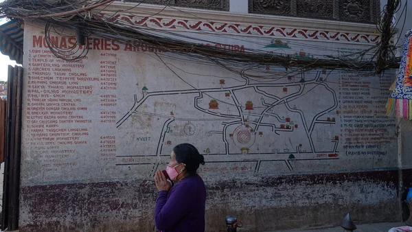 Boudha, Nepal 'deki beyaz stupada dua eden kadın.